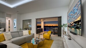 Una sala de estar moderna con un sofá, una mesa de centro y un televisor montado en la pared.