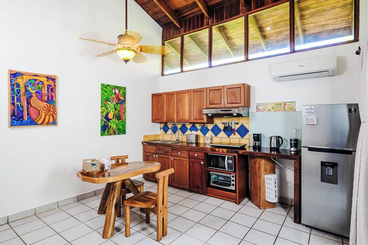 A kitchen with wooden cabinets, a built-in oven, a microwave, and a refrigerator.