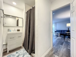 A modern bathroom with a vanity, mirror, and shower curtain. - 1 Bed Altamonte Springs Apartment Unit #3 (Altamonte Springs)