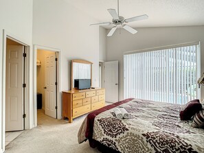 Enjoy a restful stay in this cozy room featuring a large bed, dresser, and mirror.