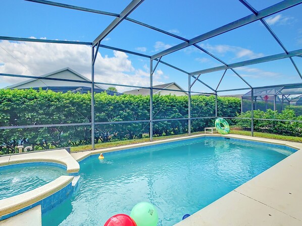 Relax by the pool surrounded by lush greenery and enjoy a refreshing dip in the main pool or unwind in the adjacent hot tub.