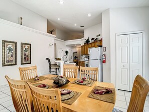 Enjoy meals in this dining area with a table for four, surrounded by matching chairs and framed artworks.