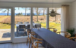 Un espace repas comprenant une table et des chaises, un chandelier et une vue sur l’extérieur.