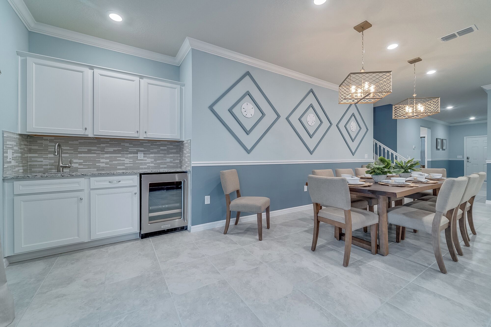 A modern kitchen with white cabinets, a built-in oven, and a tiled backsplash.