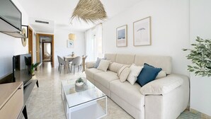 A modern living room with a sofa, coffee table, and dining area.