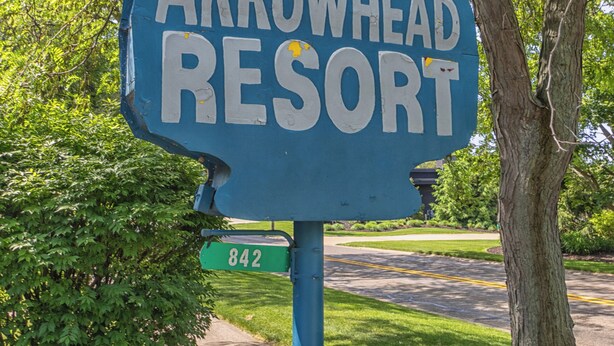 Une enseigne pour le complexe Arrowhead Resort, avec le nom « Saugatuck » et le numéro « 842 » sur un fond bleu.