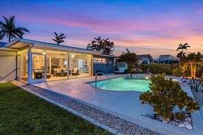 A modern house with a swimming pool, a covered patio, and a well-maintained garden. - Gulf Access, Dock, Fish Station, Kayaks, Heated Pool - Villa Palm Tree Paradise - Roelens (Cape Coral)