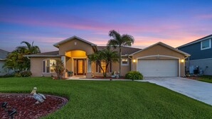 A residential house with a well-maintained lawn, a driveway, and a garage.