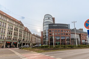 A street with a mix of historic and modern buildings, including a prominent curved glass building.