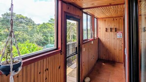 A corridor with wooden walls and a view of greenery outside. - Miztli Lodge & Adventures (Monteverde)