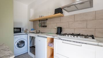 Køleskab, mikrobølgeovn, køkkentøj/tallerkener/redskaber, spisebord