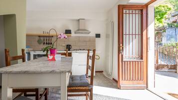 Køleskab, mikrobølgeovn, køkkentøj/tallerkener/redskaber, spisebord