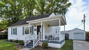 A single-story house with a front porch, a garage, and a well-maintained lawn. - 4BR Norfolk Home • Game Room • Dog Friendly (Norfolk)