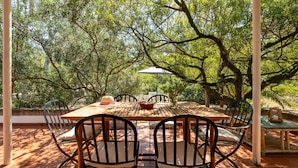 An outdoor dining area with a wooden table and chairs, surrounded by trees. - Villa Angela by Interhome (Pula)
