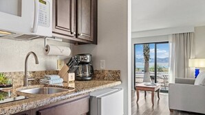 Una cocina moderna con encimeras de granito, horno empotrado y cafetera.