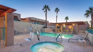 A pool area with a hot tub, lounge chairs, and palm trees. - Lake Havasu City | Couples Lake Retreat | Pool + Hot Tub (Lake Havasu)