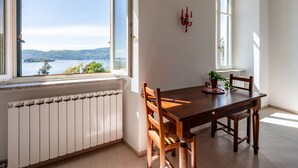 A dining area with a table and chairs, a view of a lake, and a radiator.