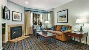 A living room with a fireplace, a sofa, a coffee table, and a lamp.