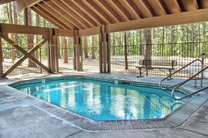 Ein Hallenbad mit Holzdeck und Metallgeländer.