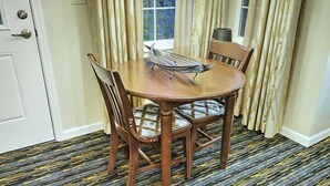 A dining area with a round table, four chairs, and a window with curtains. - Pinetop | Couples Forest Hideaway | Hot Tub + Mountains (Pinetop)