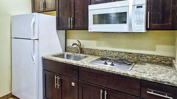 A kitchen with a refrigerator, microwave, stove, and granite countertop. - Pinetop | Couples Forest Hideaway | Hot Tub + Mountains (Pinetop)