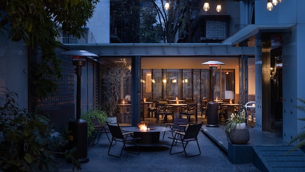 An outdoor patio area with a fire pit, seating, and string lights. - WEZO HOTEL CHENGDU (Chengdu)