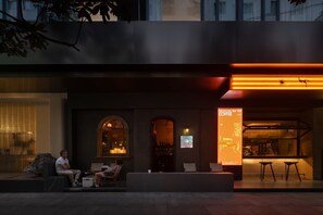 An outdoor seating area with a modern design, featuring a bar and a display screen. - WEZO HOTEL CHENGDU (Chengdu)