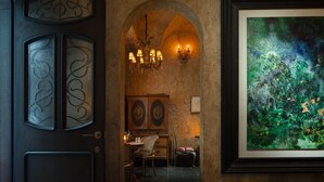 A hallway with a dark door, an arched passageway, a chandelier, and a framed abstract painting. - WEZO HOTEL CHENGDU (Chengdu)