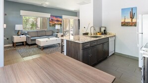 Une cuisine moderne avec des meubles de couleur sombre, un plan de travail en marbre et un lave-vaisselle encastré.