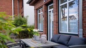 Eine Terrasse mit Tisch, Stühlen und einer Sitzecke.
