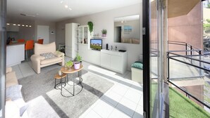 Een modern appartement met een woonkamer, keuken en balkon.