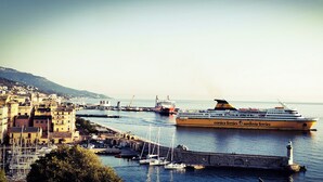 A coastal town with a ferry dock, a bridge, and a lighthouse.