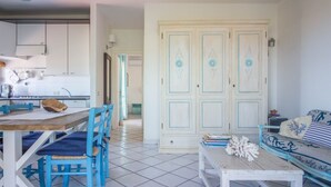 Une pièce comprenant une table à manger, des chaises, un canapé et une armoire.