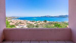 Un balcon avec vue sur une ville côtière et la mer.