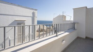 A balcony with a metal railing, a white building, and a view of the sea. - GuestHost - Beautiful apartment that accommodates up to 4 people, equipped with all the comforts for a pleasant stay, including a furnished sea-view terrace to enjoy unmissable moments of relaxation. The accommodation is located in a period building with (Monopoli)