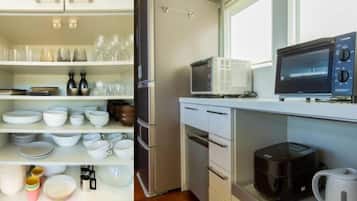 A kitchen with white cabinets, a refrigerator, a microwave, a coffee maker, and various dishes and utensils.