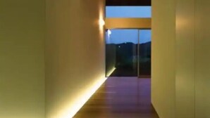 A modern hallway with a wooden floor and a glass door leading to a balcony with a view of the night sky. - THE SATOYAMA HILLS　FK1 (Futtsu)