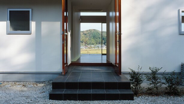A modern building with a wooden sloped roof, a glass entrance, and a view of the landscape. - THE SATOYAMA HILLS　FK1 (Futtsu)