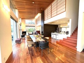 A modern interior with a dining area, kitchen, and staircase.