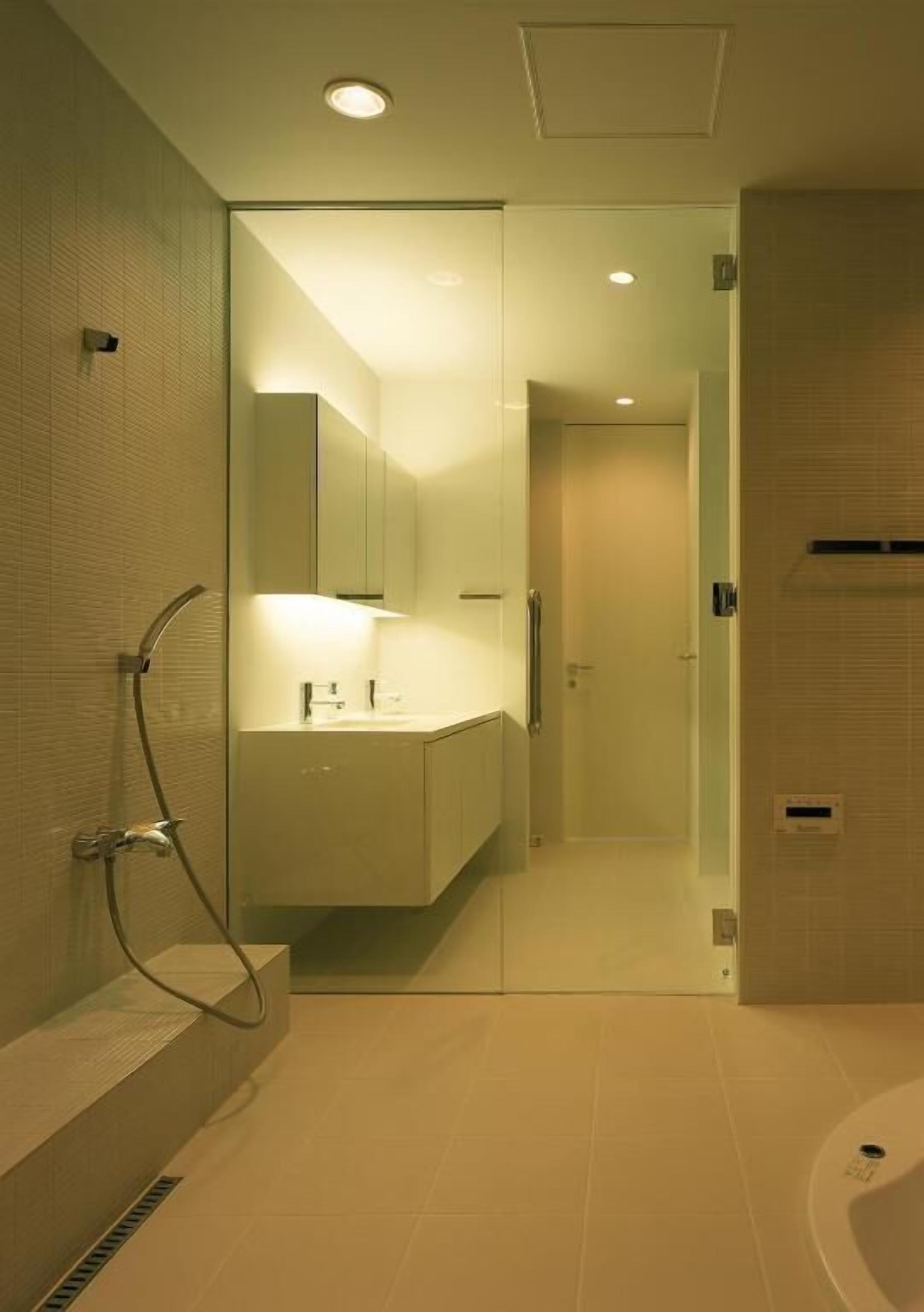 Ein modernes Badezimmer mit Duschkabine aus Glas, integriertem Waschtisch und separater Badewanne.