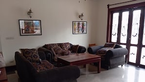 A living room with a sofa set, a coffee table, and two wall-mounted lamps.