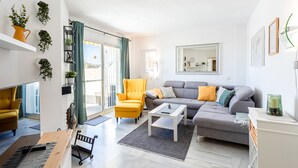 Un salon moderne avec un canapé, des fauteuils et une table basse.