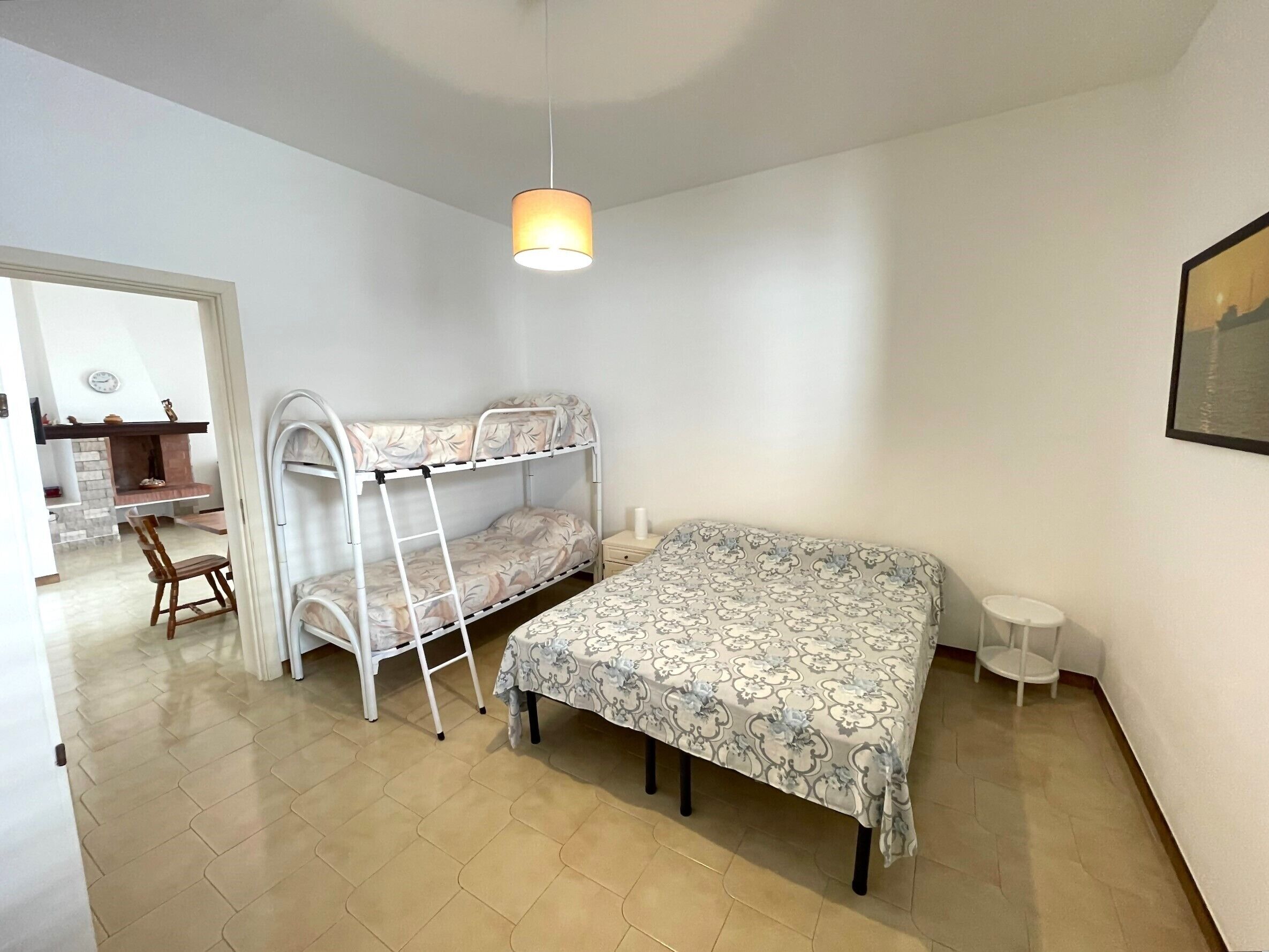 A bedroom with bunk beds, a desk, and a chair.