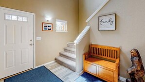 Ein Wohndekor mit Treppe, einer Holzbank und einer Wand mit der Aufschrift 'Family'.