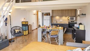 A modern apartment with a dining area, kitchen, and a loft bedroom. - Casa Sémaphore (L'Île-Rousse)