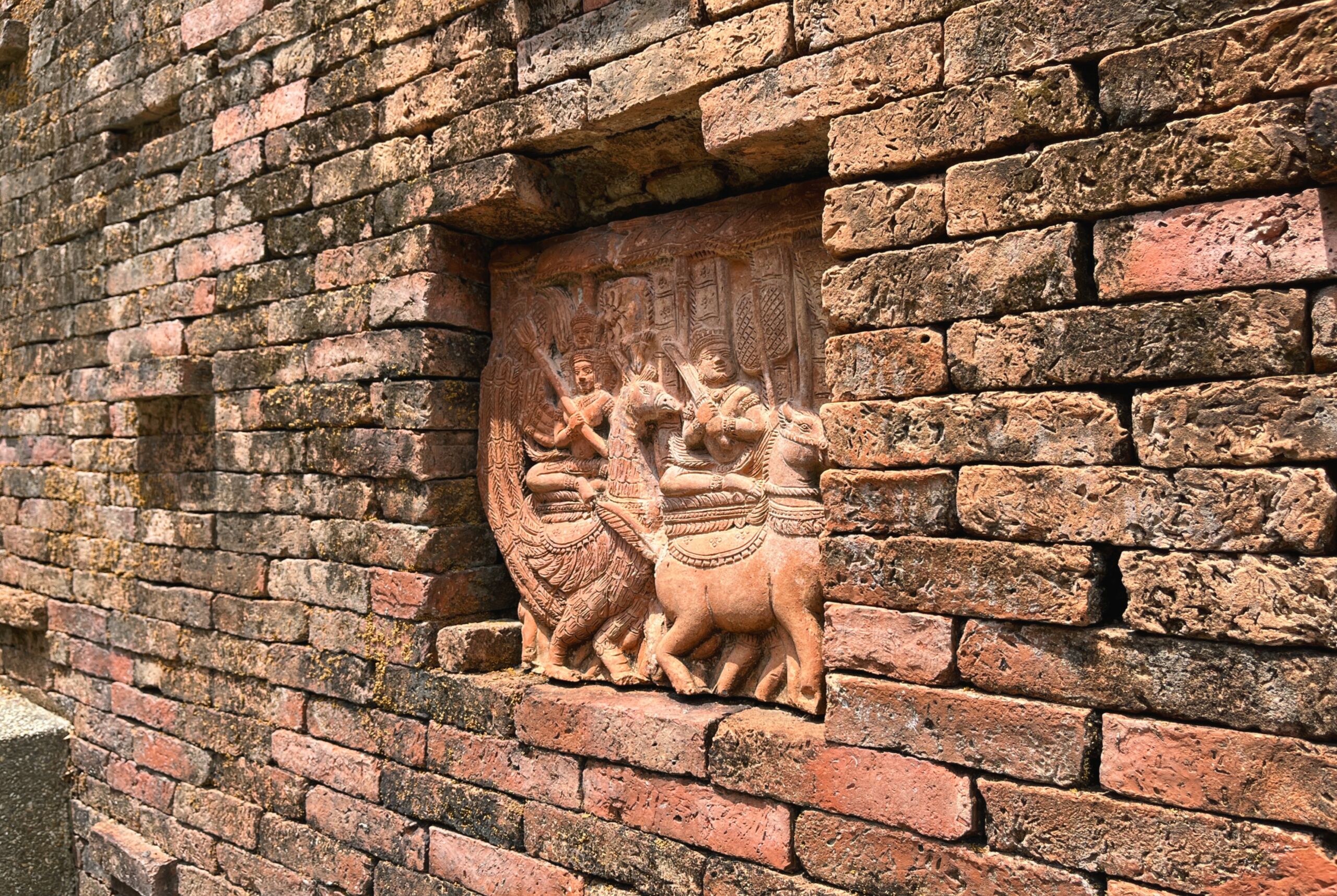 A detailed stone carving on a brick wall.