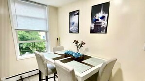 Un comedor con una mesa, sillas y una ventana con persianas.