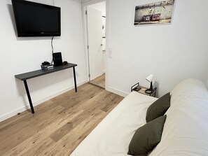 A bedroom with a bed, a desk with a computer, a TV, and a painting on the wall. - Complete rural house for 6 people in Pedralba (Valencia). (Pedralba)