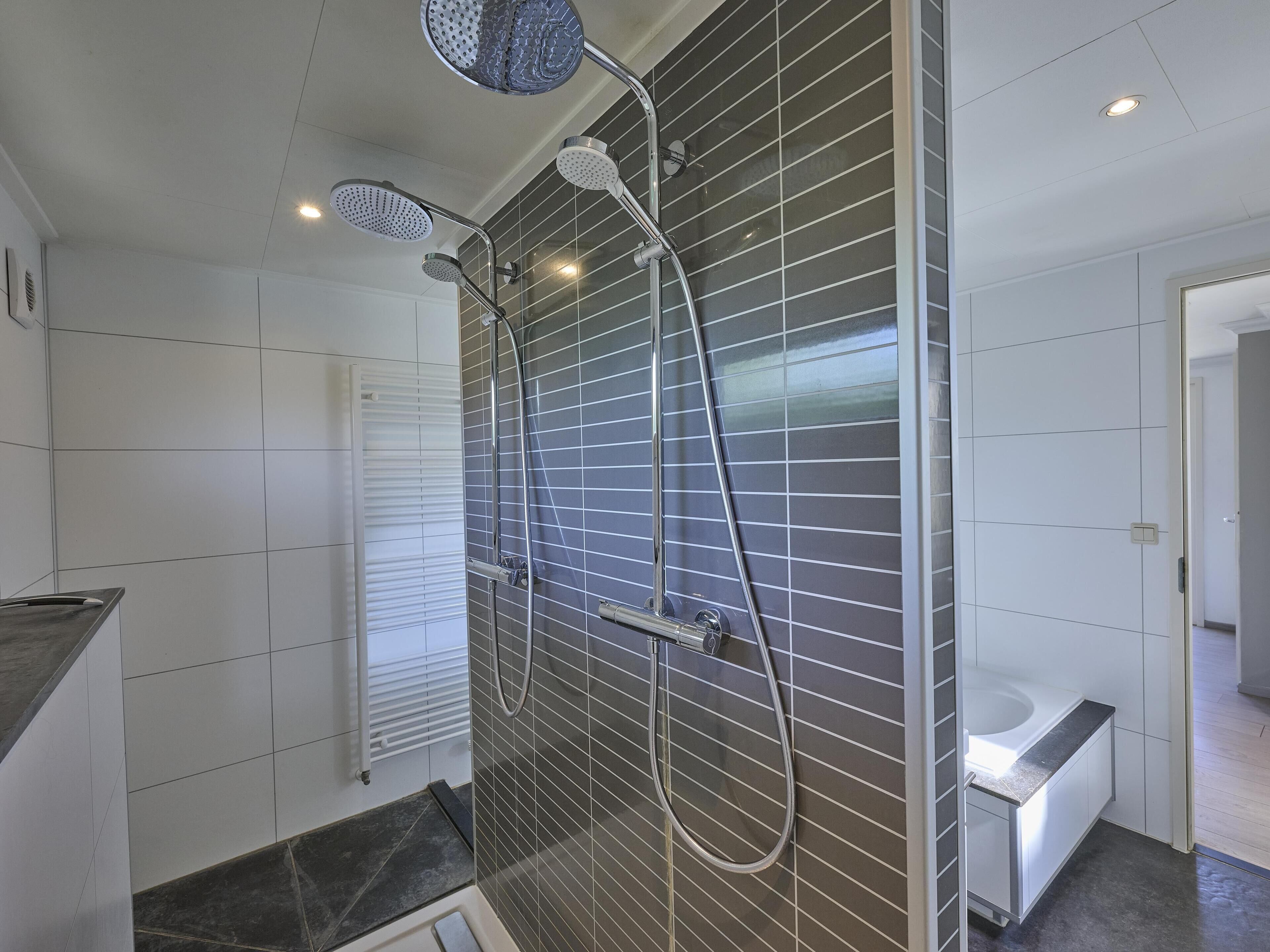 A modern bathroom with a shower, a toilet, and a sink.