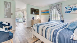 A bedroom with a large bed, a desk, and a chair. There is a window with curtains and artwork on the walls. - ‘Livin Wells' Retreat, 2 Mi to Drakes Island Beach (Wells)